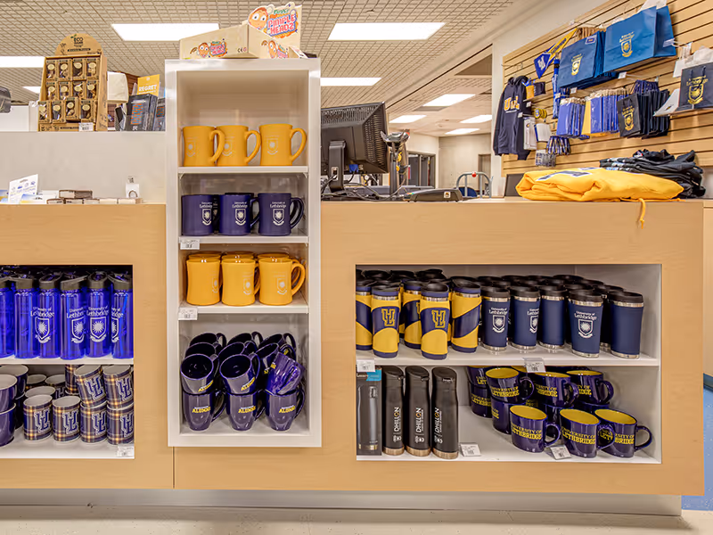 Close-up of custom retail shelving at the University of Lethbridge Bookstore featuring branded merchandise.