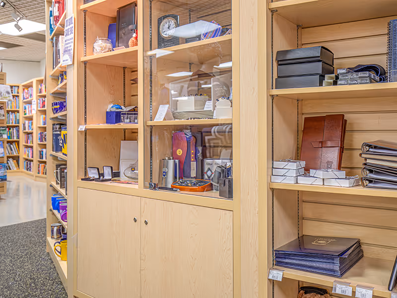 Glass-front display cabinetry inside the University of Lethbridge Bookstore for premium merchandise.
