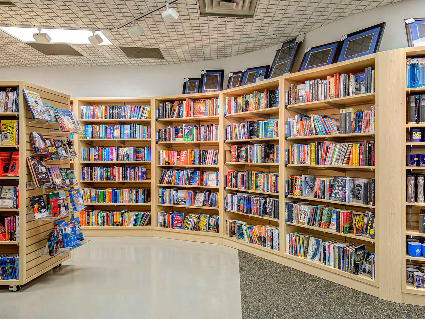 Curved bookstore shelving layout at the University of Lethbridge showcasing books and improved traffic flow.