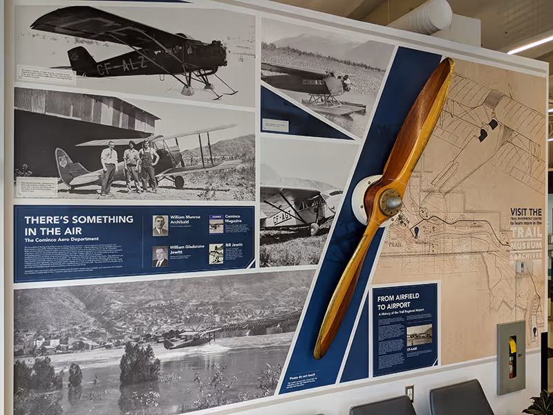 Close-up of the aviation history wall at Trail Regional Airport with historic aircraft imagery and interpretive signage.