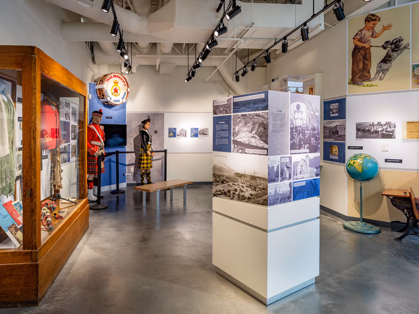 Cultural history exhibit with traditional attire, artifacts, and interpretive panels inside the Trail museum.