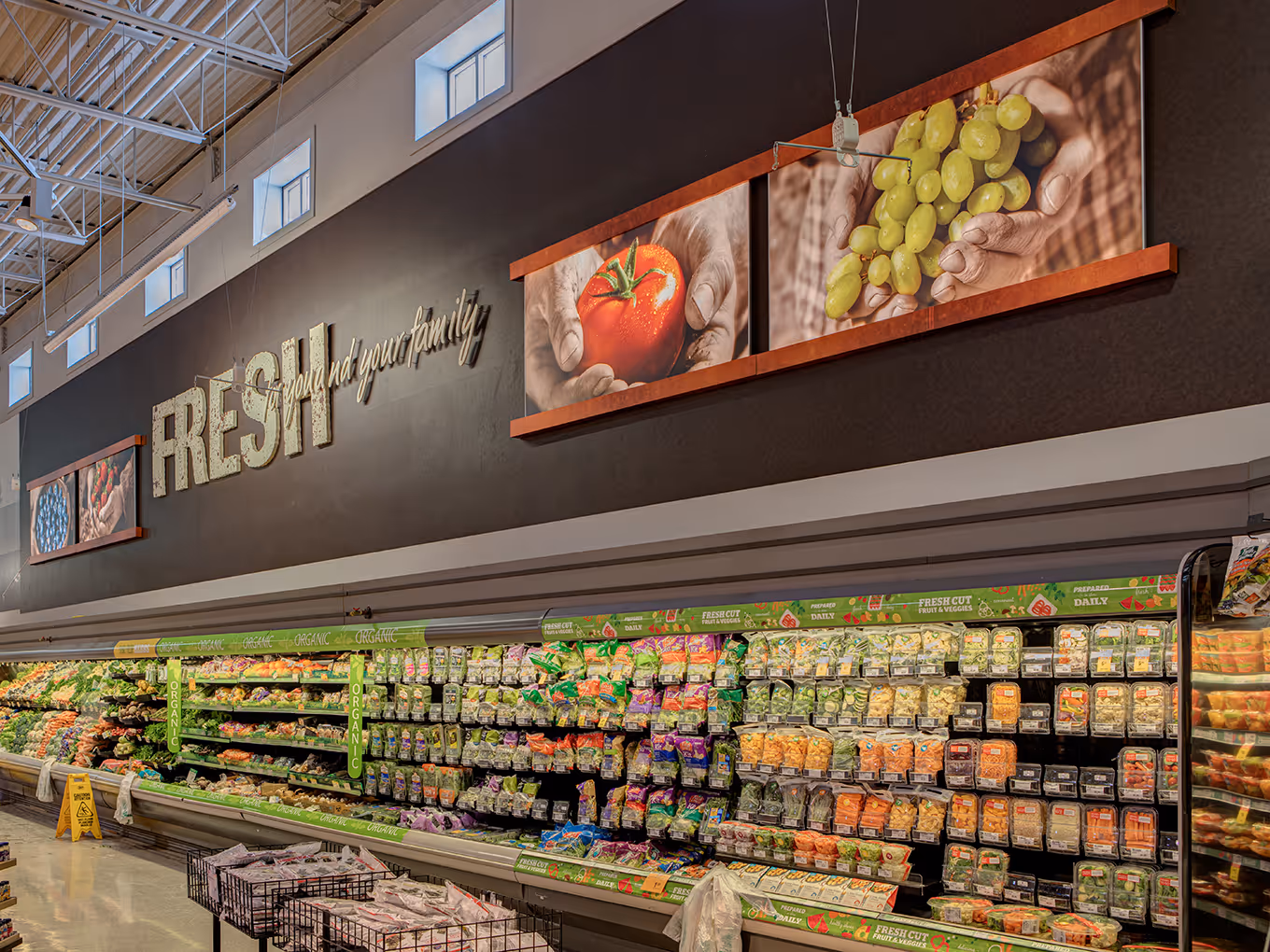 Wide view of custom illuminated Signbright panels guiding shoppers through the produce department at Calgary Co-op.