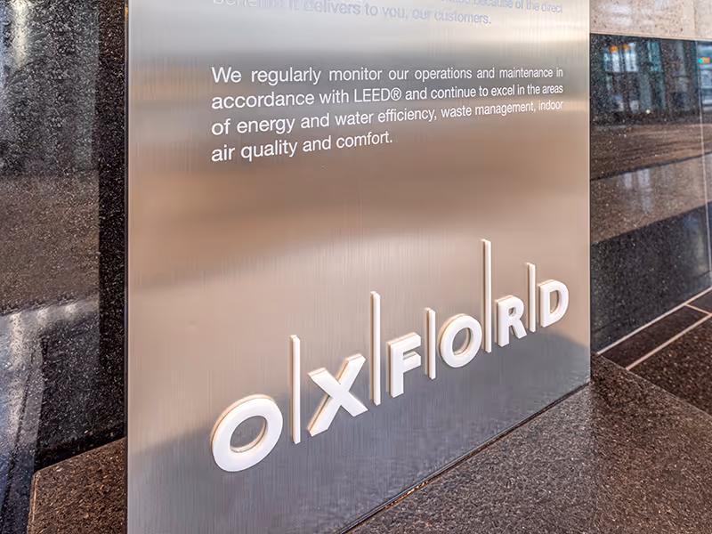 LEED Platinum award plaques mounted on brushed aluminum panel using stand-off hardware.