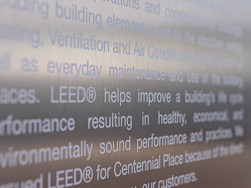 Close-up of brushed aluminum surface with applied white text describing LEED sustainability standards.