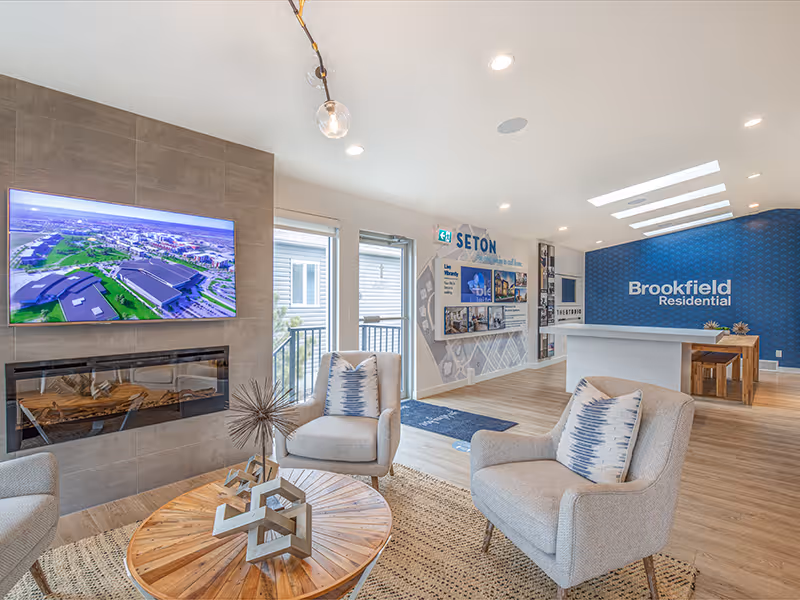 Interior sales centre display wall highlighting the Seton community through lifestyle imagery, digital screens, and informational panels.