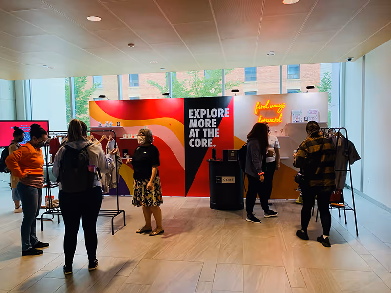 Retail-style NorQuest College pop-up featuring illuminated signage, product displays, and branded graphics.