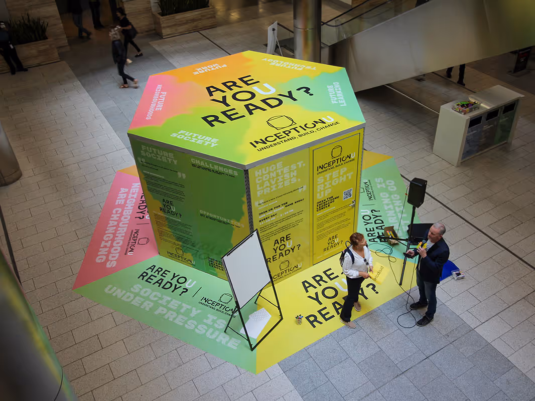 Colorful experiential marketing installation with large hexagon display reading “Are You Ready?” and InceptionU branding in a public atrium space.
