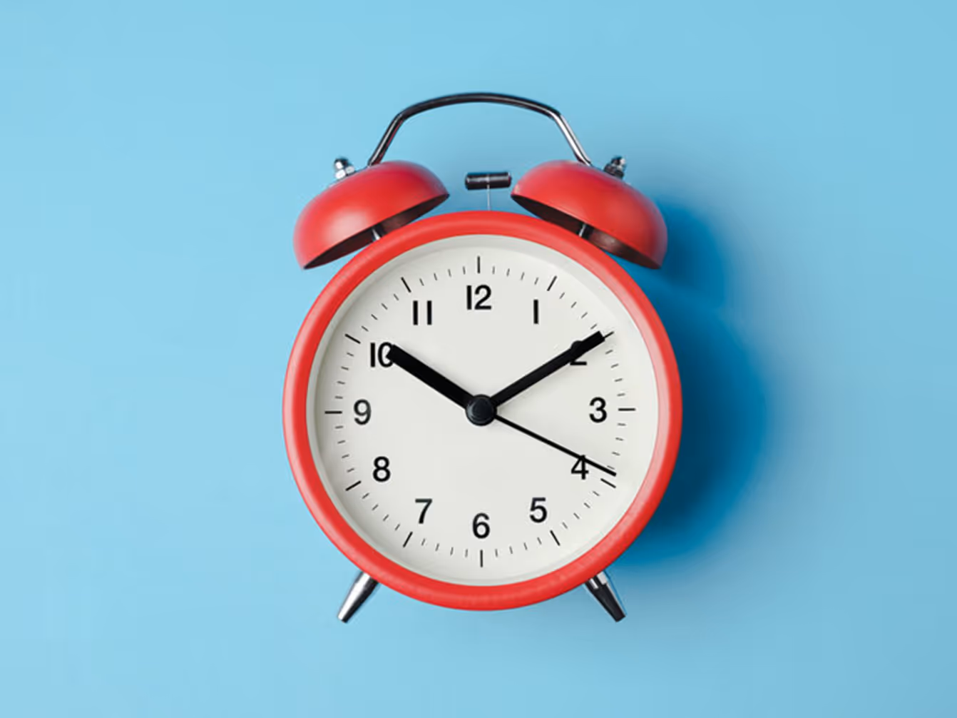 Red alarm clock on blue background representing the three-second rule in trade show booth design.