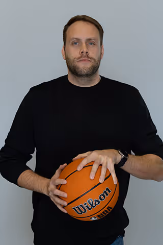 Account Manager holding a basketball with a serious facial expression