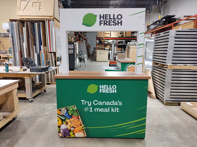 Custom HelloFresh activation counter built by Exhibit Studio with removable graphics and wood countertop, designed for meal kit sampling and event demonstrations.