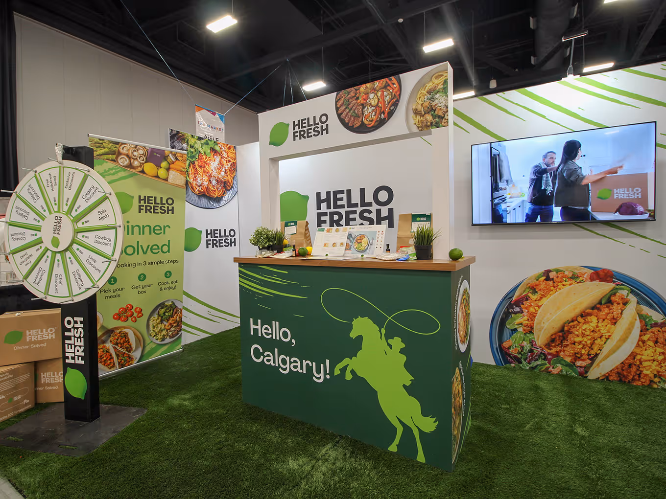 Front view of HelloFresh 10x20 booth display with Calgary Stampede themed counter graphics, meal kit presentation area, and branded fabric trade show backdrop.