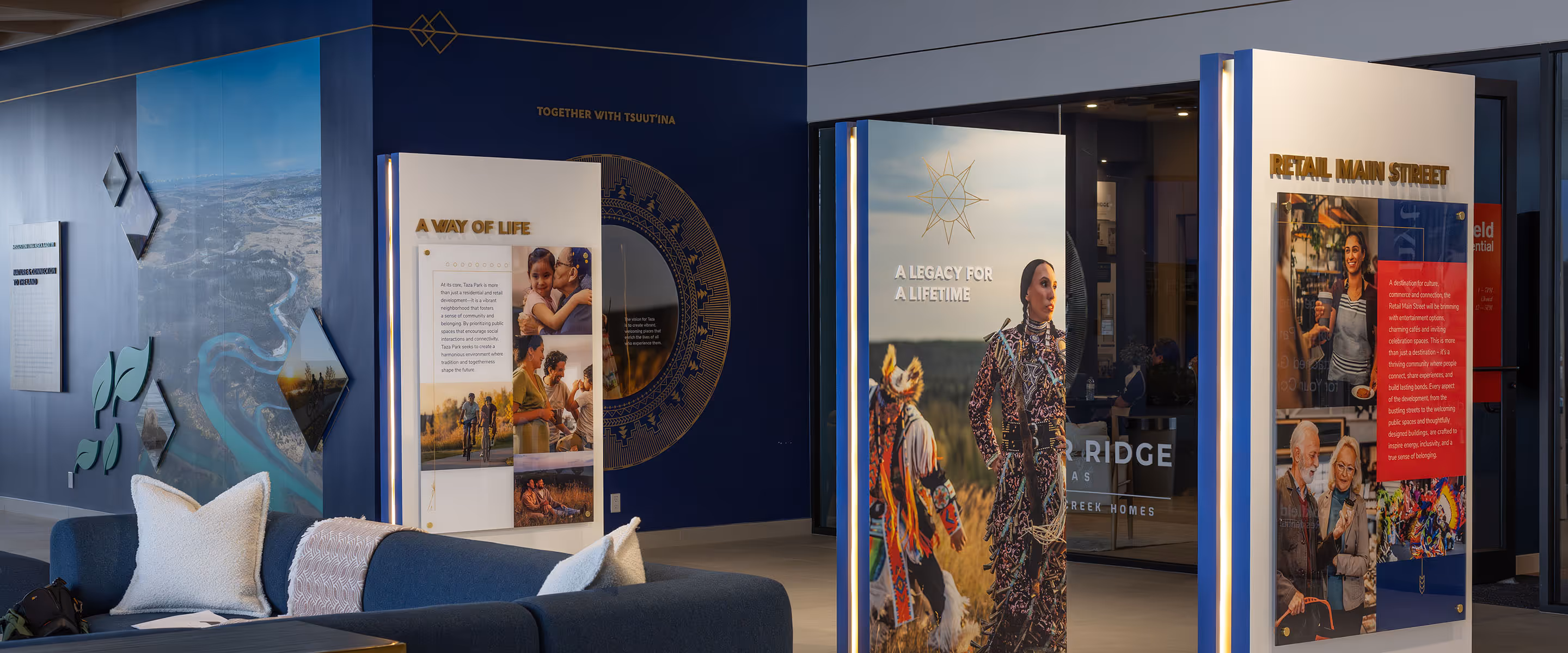 Wide-angle view of Taza Park marketing centre displays featuring "A Way of Life," "A Legacy for a Lifetime," and "Retail Main Street" branded panels.