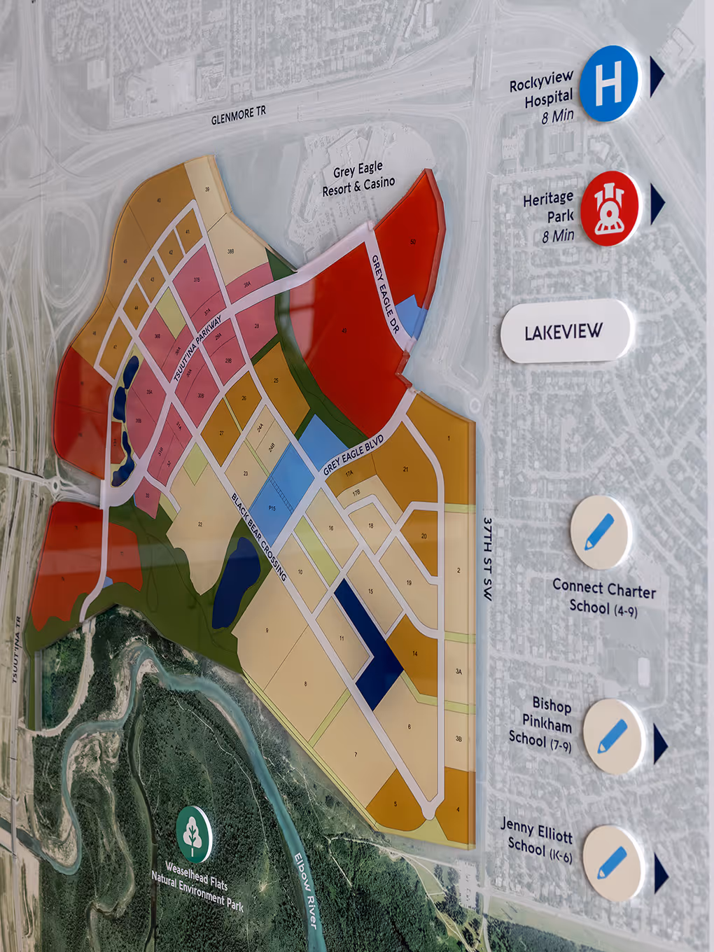 Close-up of Taza Park master plan site map display showing colour-coded land use zones, Grey Eagle Resort, Weaselhead Flats, and nearby schools.