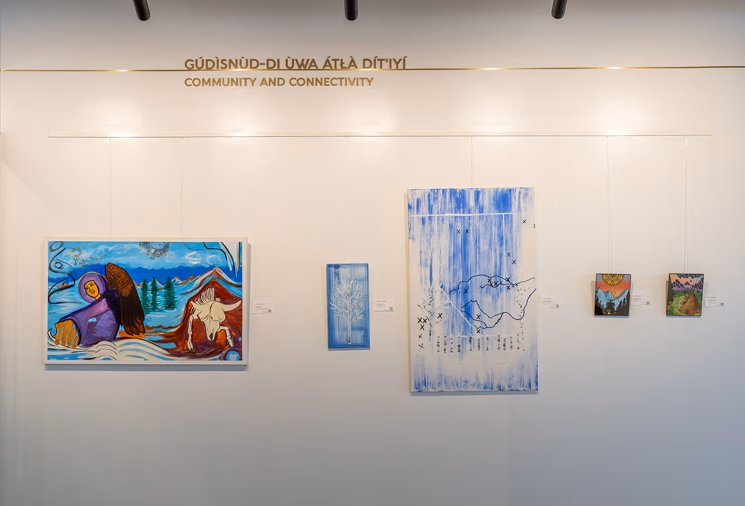 Gallery wall in Taza Park marketing centre featuring Indigenous artwork under the heading "Community and Connectivity" in Tsuut'ina and English.