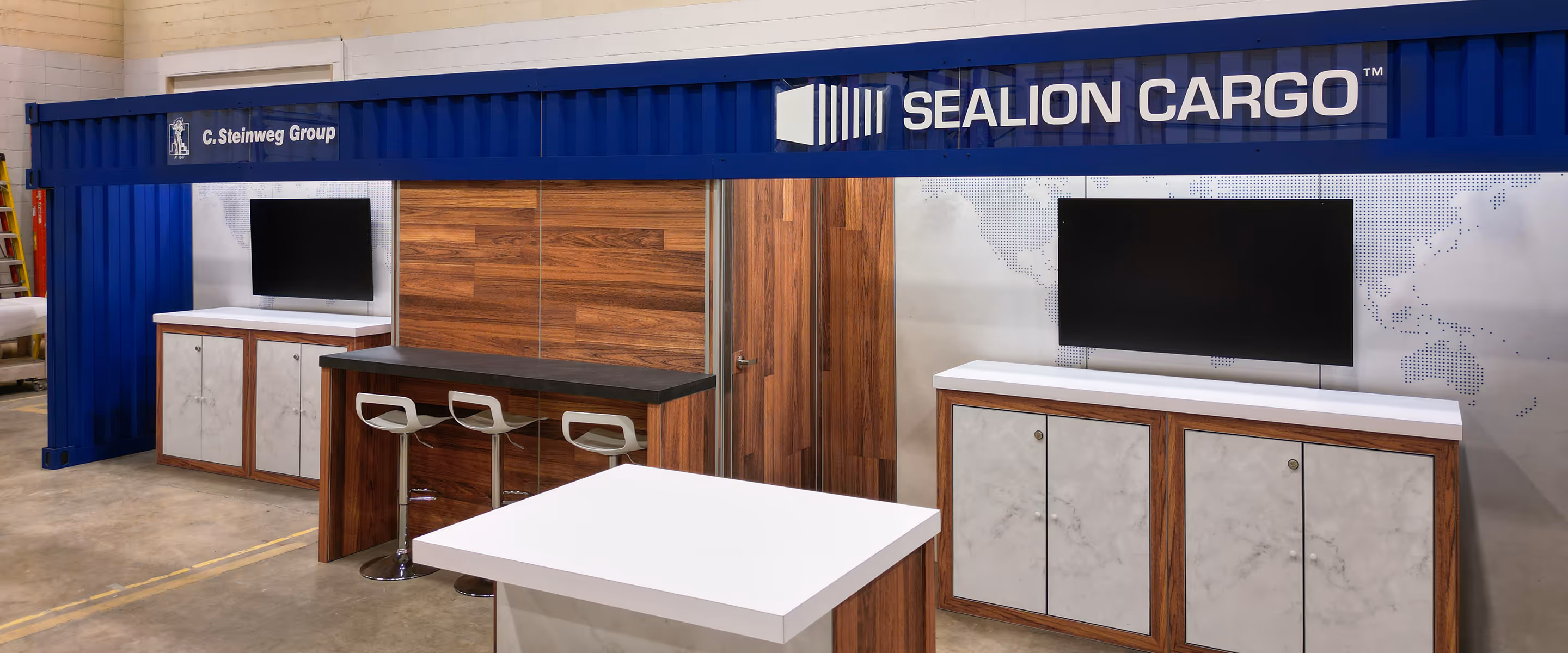 Custom 10x30 shipping container trade show booth with wood finishes, counters, and integrated displays for Sealion Cargo exhibit.