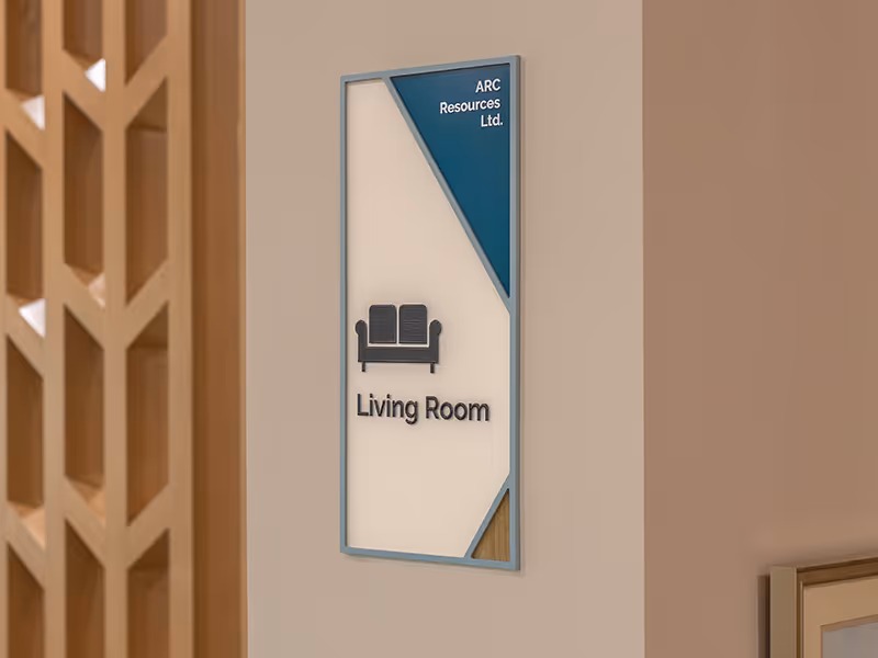 Custom room identification sign for the Magic Room at Ronald McDonald House Alberta Calgary House, featuring a painted blue acrylic frame, teal sponsor corner for Avison Young Commercial Real Estate, dimensional rabbit-in-hat icon, braille panel, and wood 