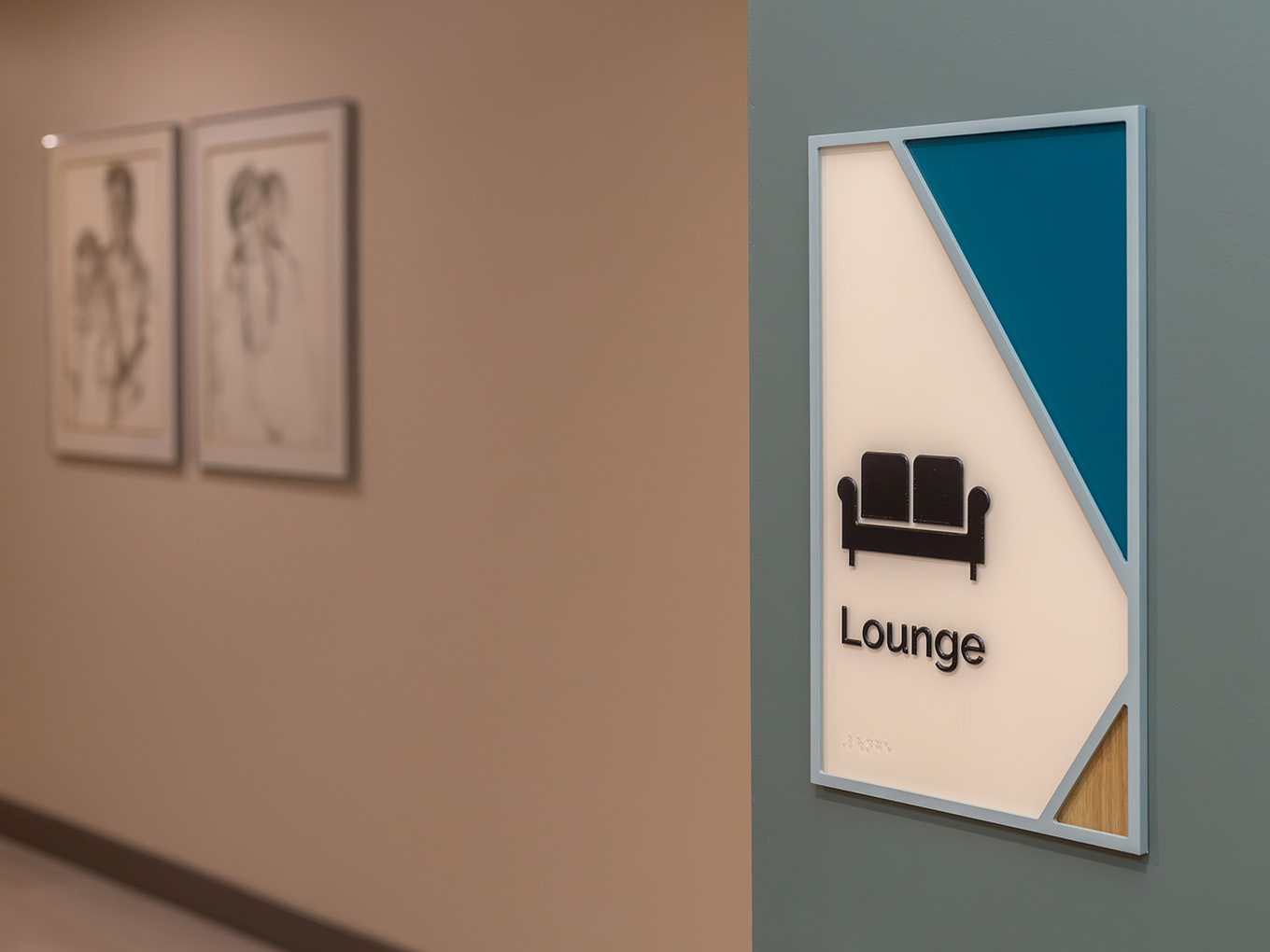 Custom wayfinding room ID sign for the Lounge at Ronald McDonald House Alberta, with dimensional sofa icon, braille panel, teal and wood grain graphics.