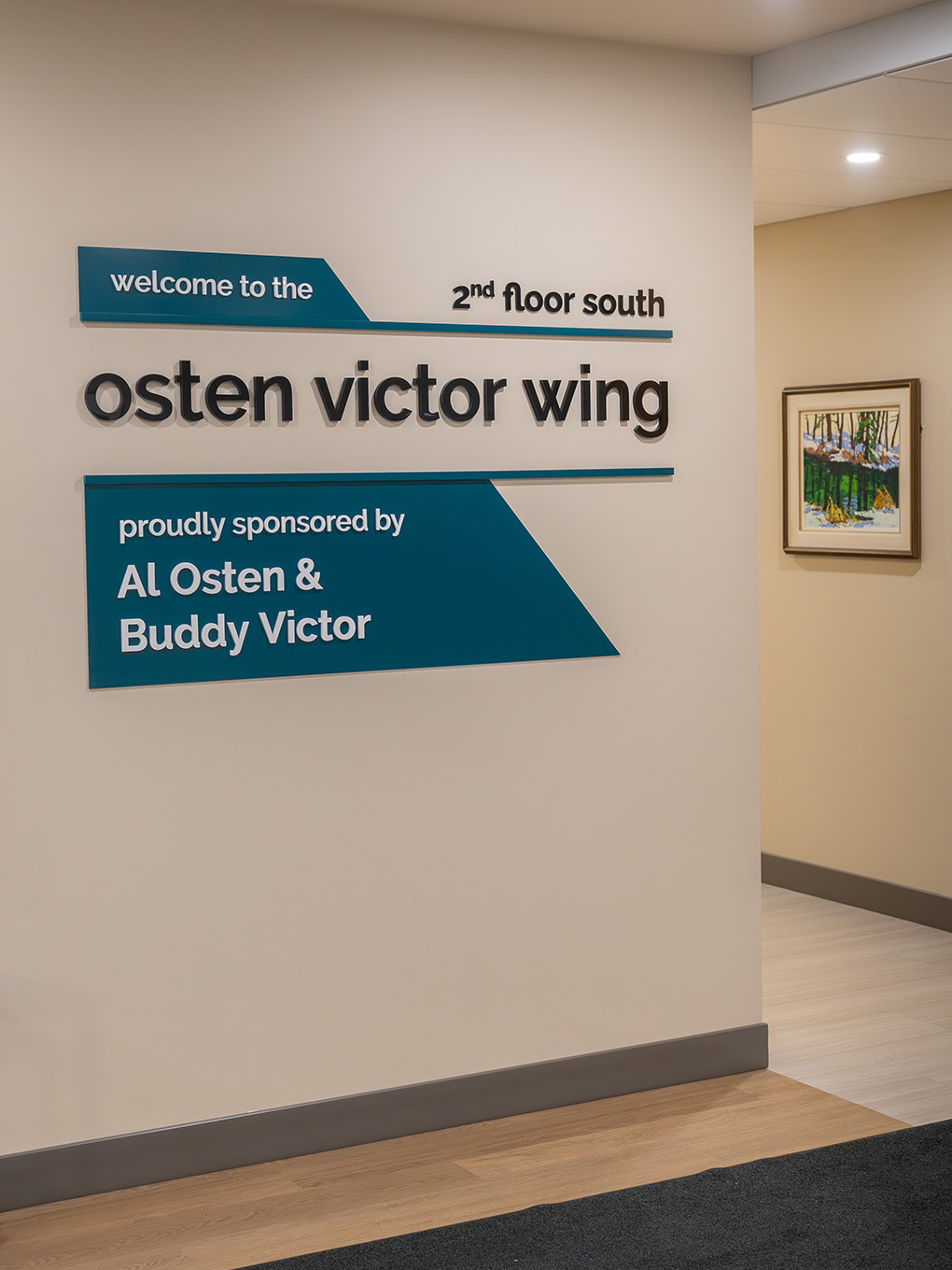 nstalled building wing signage for the Osten Victor Wing at RMHC Calgary House, with dimensional 3D letters and teal painted acrylic sponsor panels.