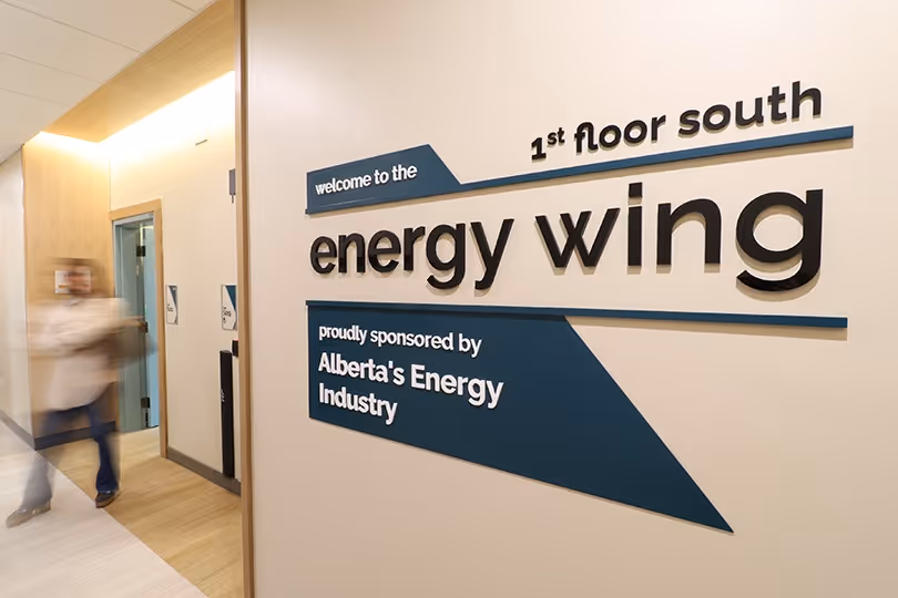 Interior wall signage reading “Energy Wing” with directional information in Ronald McDonald house charities facility corridor.