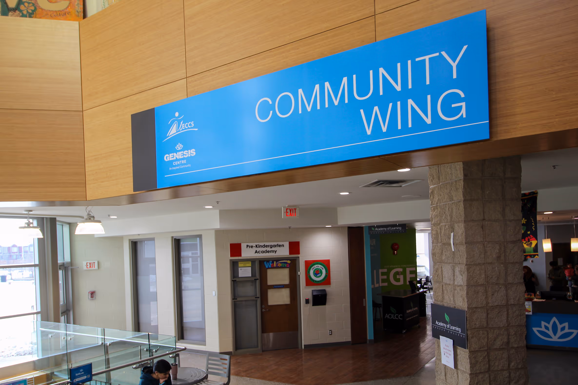 Large overhead “Community Wing” sign installed at Genesis Centre recreation facility interior.