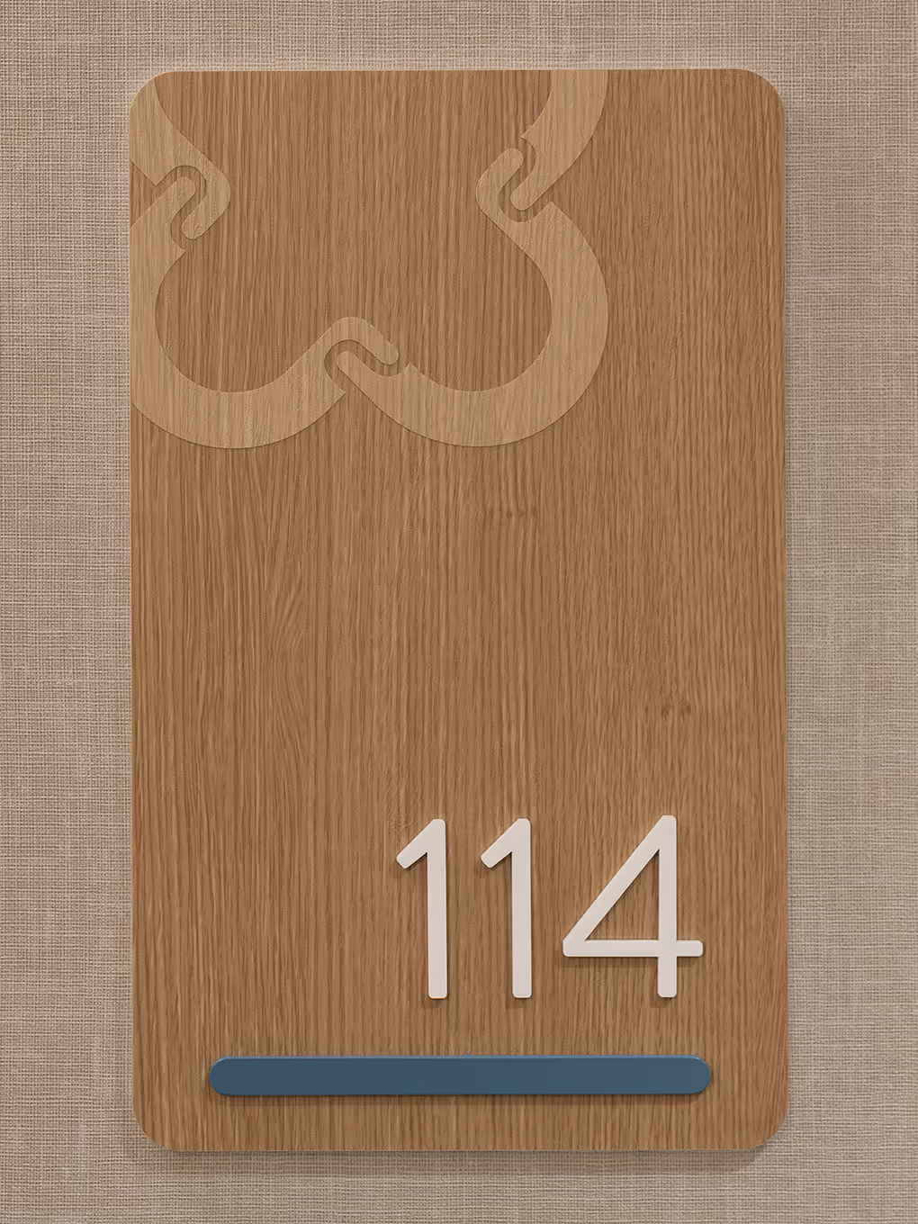 Detailed view of a custom suite identification sign at United Active Living Garrison Green, showing the wood-look BODAQ vinyl finish and the subtle United icon as a top accent.