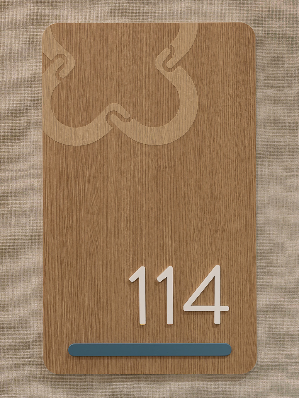 Detailed view of a custom suite identification sign at United Active Living Garrison Green, showing the wood-look BODAQ vinyl finish and the subtle United icon as a top accent.