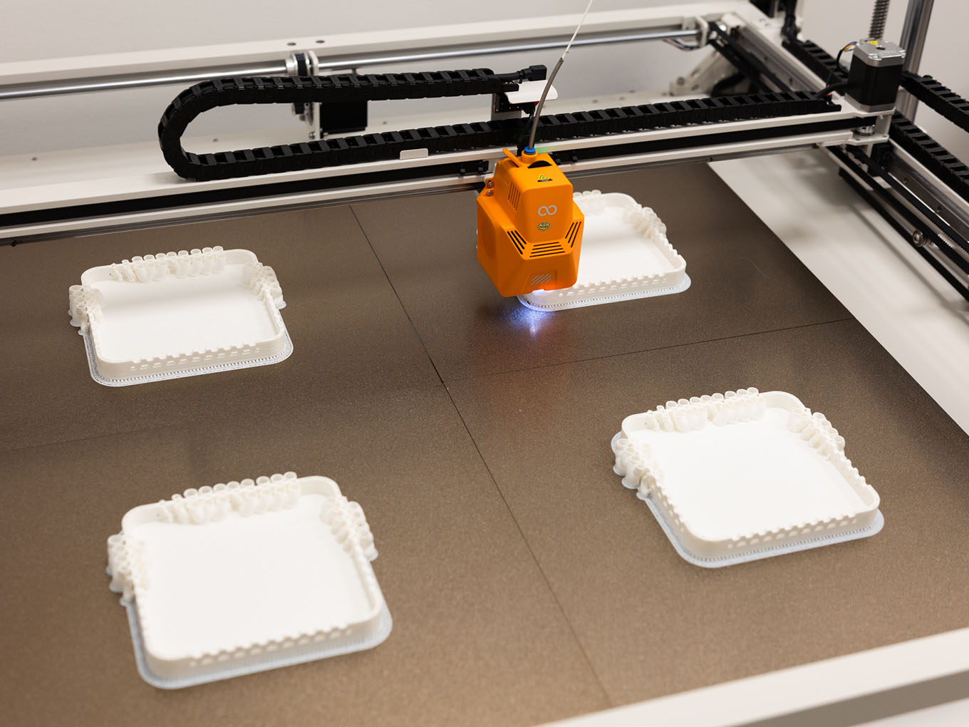 Elegoo OrangeStorm Giga print bed producing four identical parts simultaneously using multi-head 3D printing capability