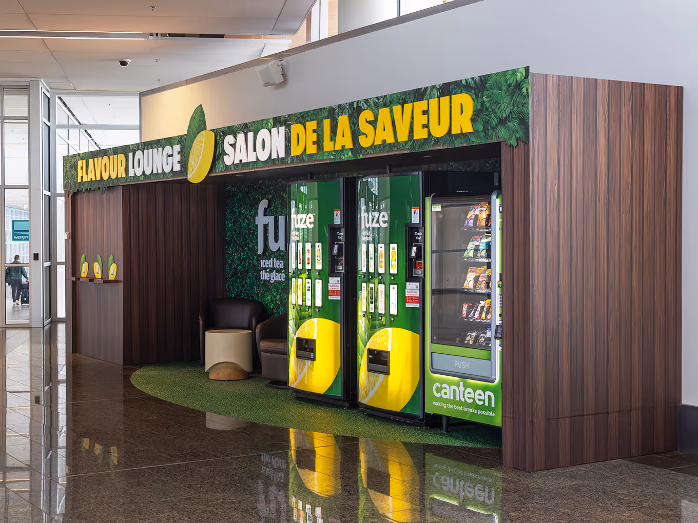 Custom-built Fuze Iced Tea Flavour Lounge kiosk with branded vending machines and artificial turf at Calgary International Airport