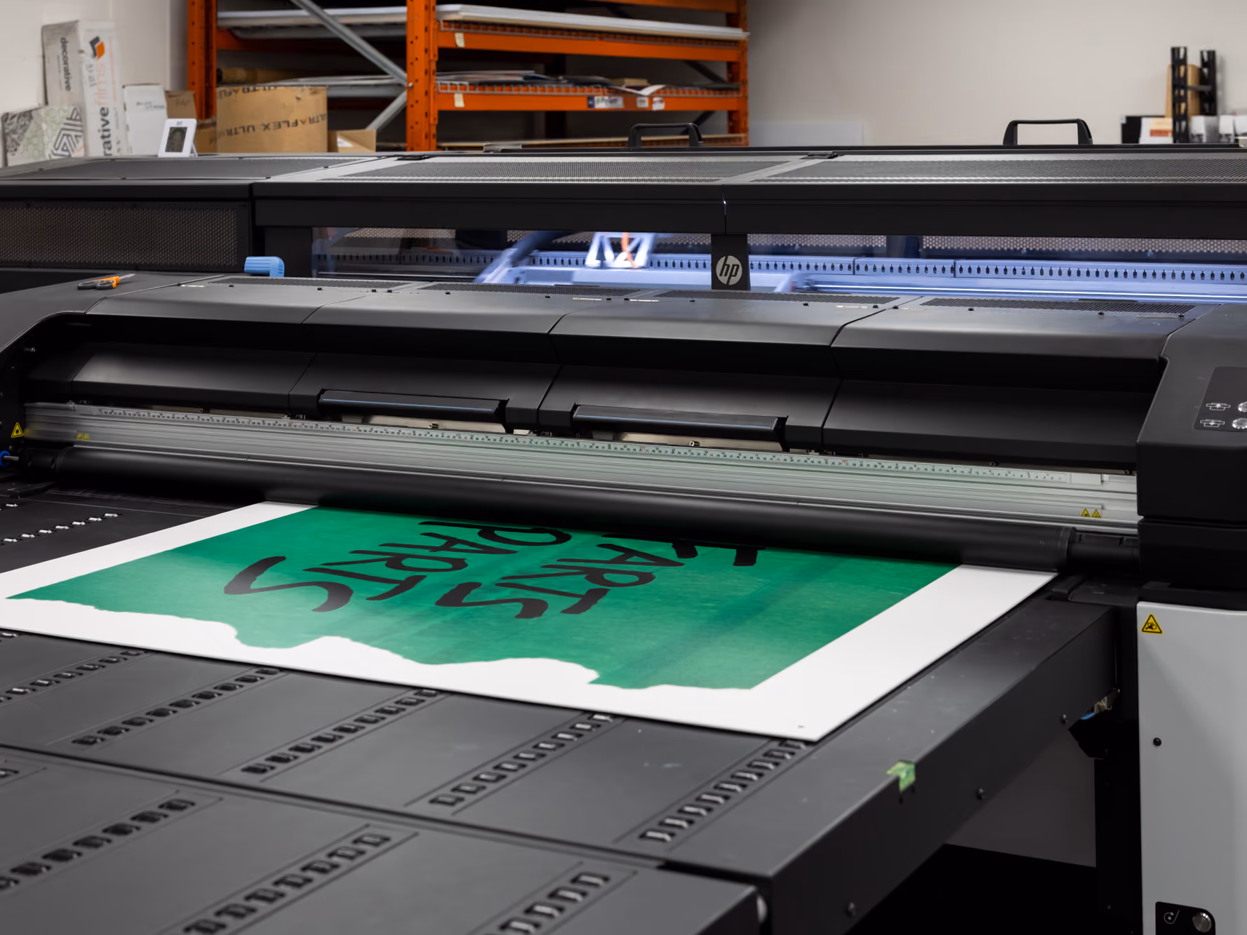 A large-format printer outputs the Young Farts Trailer Parts signage for the Calgary Stampede activation.