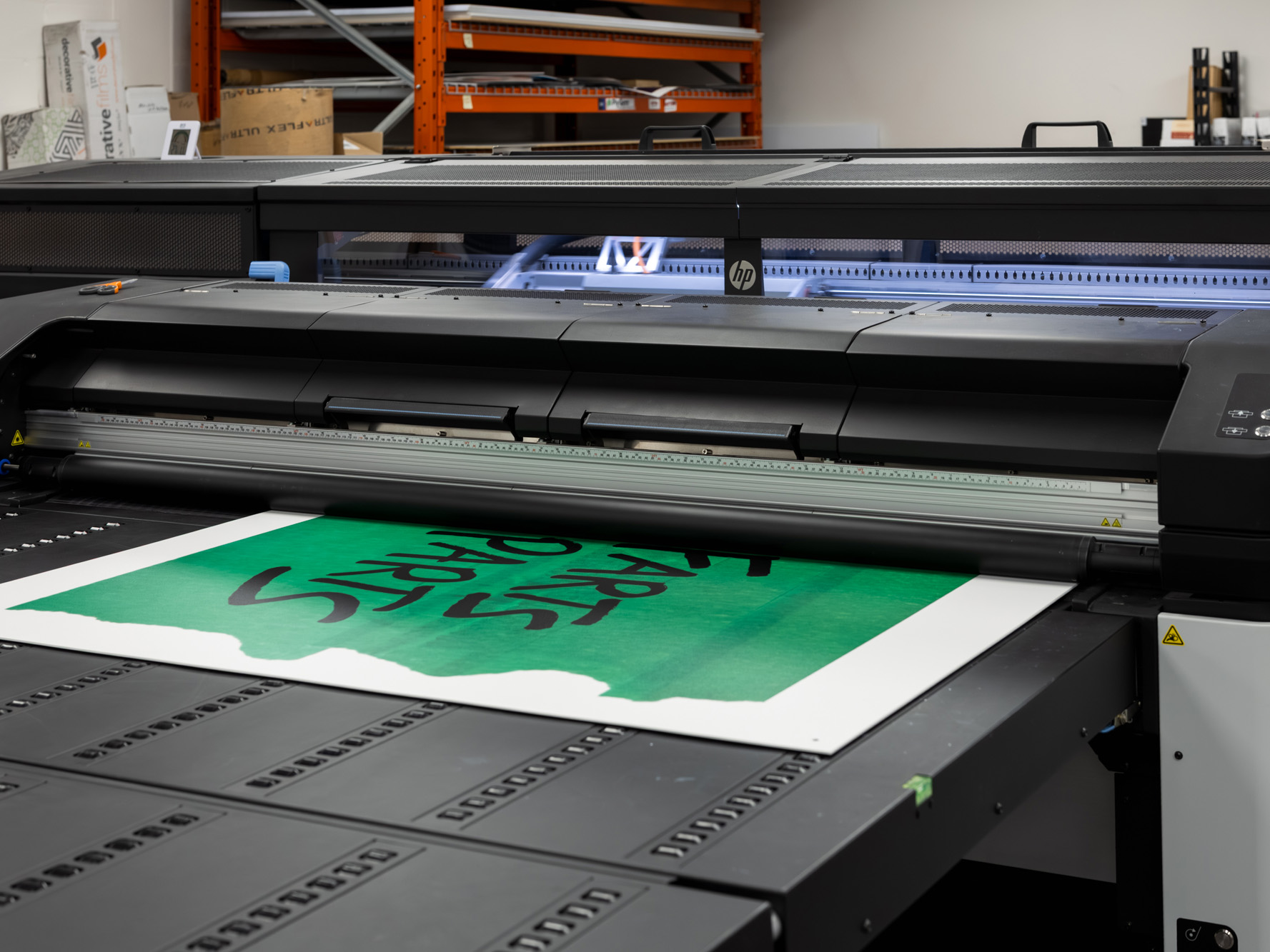 A large-format printer outputs the Young Farts Trailer Parts signage for the Calgary Stampede activation.