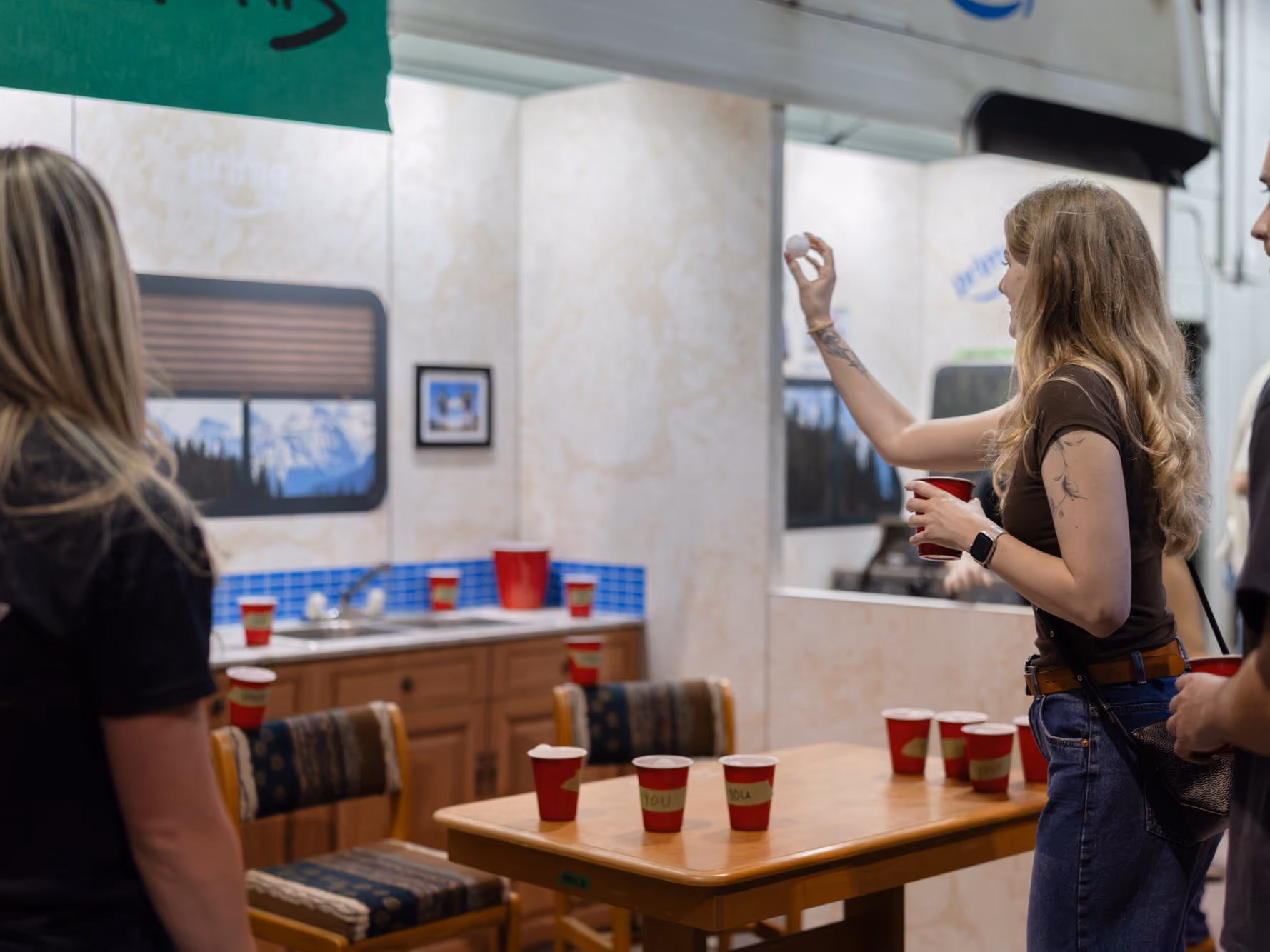 A visitor plays kitchen pong at the custom game station inside the Young Farts Trailer Parts RV activation.