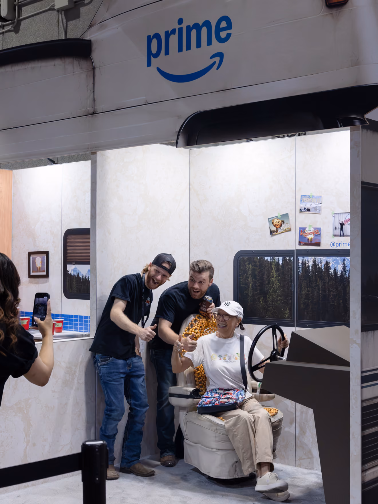 Visitors pose in the custom RV kitchen and driver's seat area at the Young Farts Trailer Parts activation, Calgary Stampede.