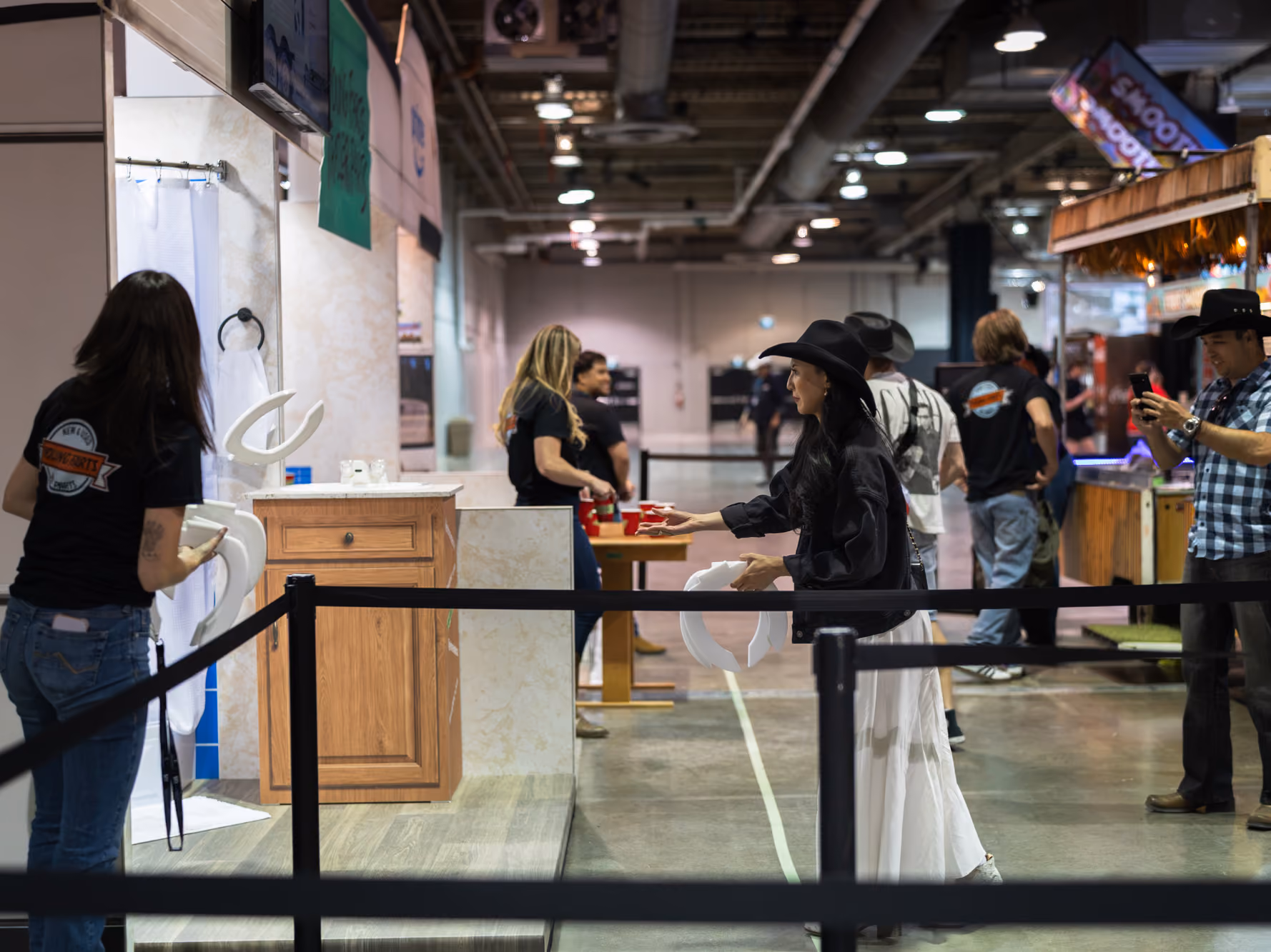 A visitor tosses a toilet seat during the horseshoe-style ring toss game at the Young Farts Trailer Parts activation.
