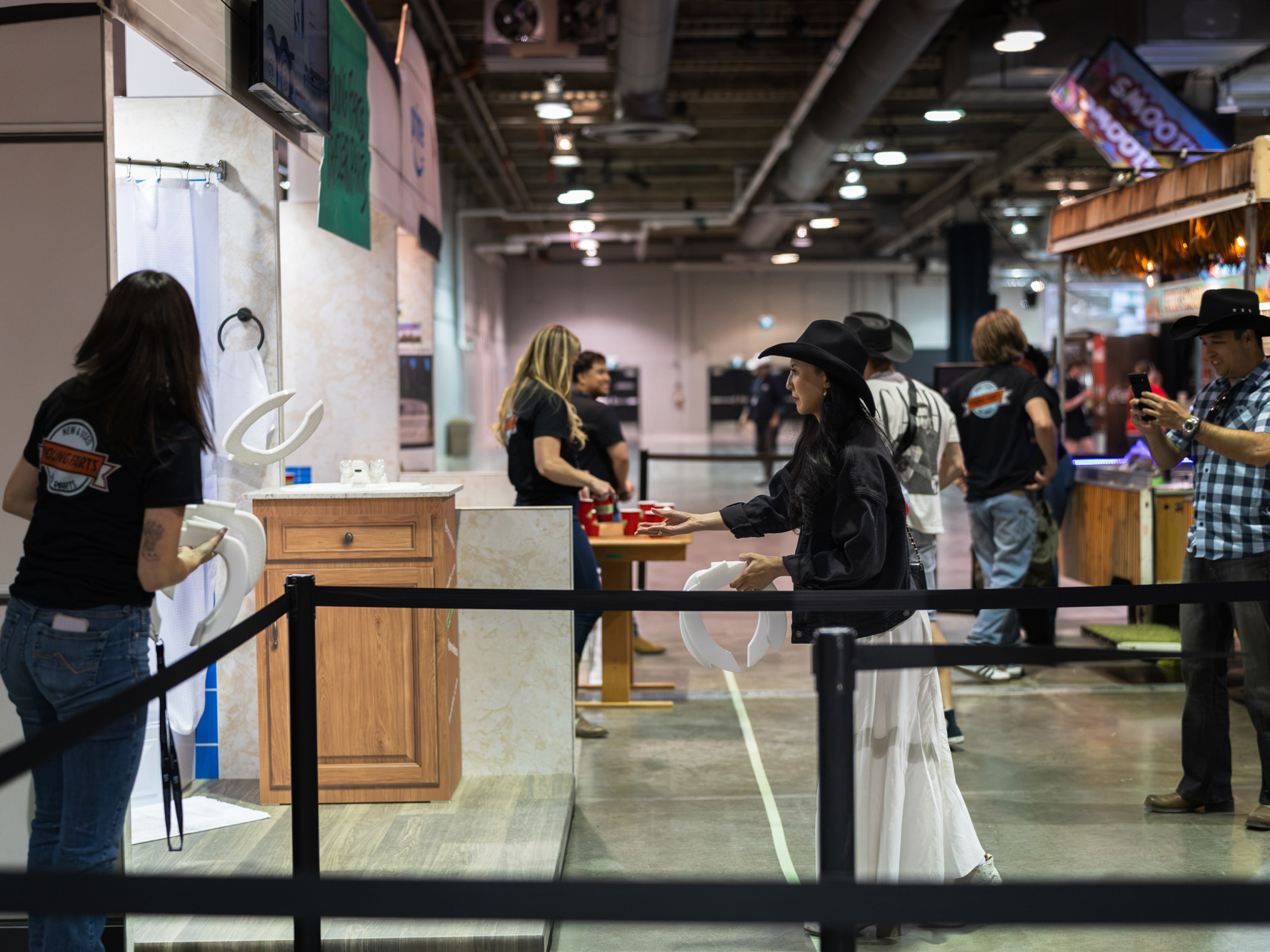 A visitor tosses a toilet seat during the horseshoe-style ring toss game at the Young Farts Trailer Parts activation.