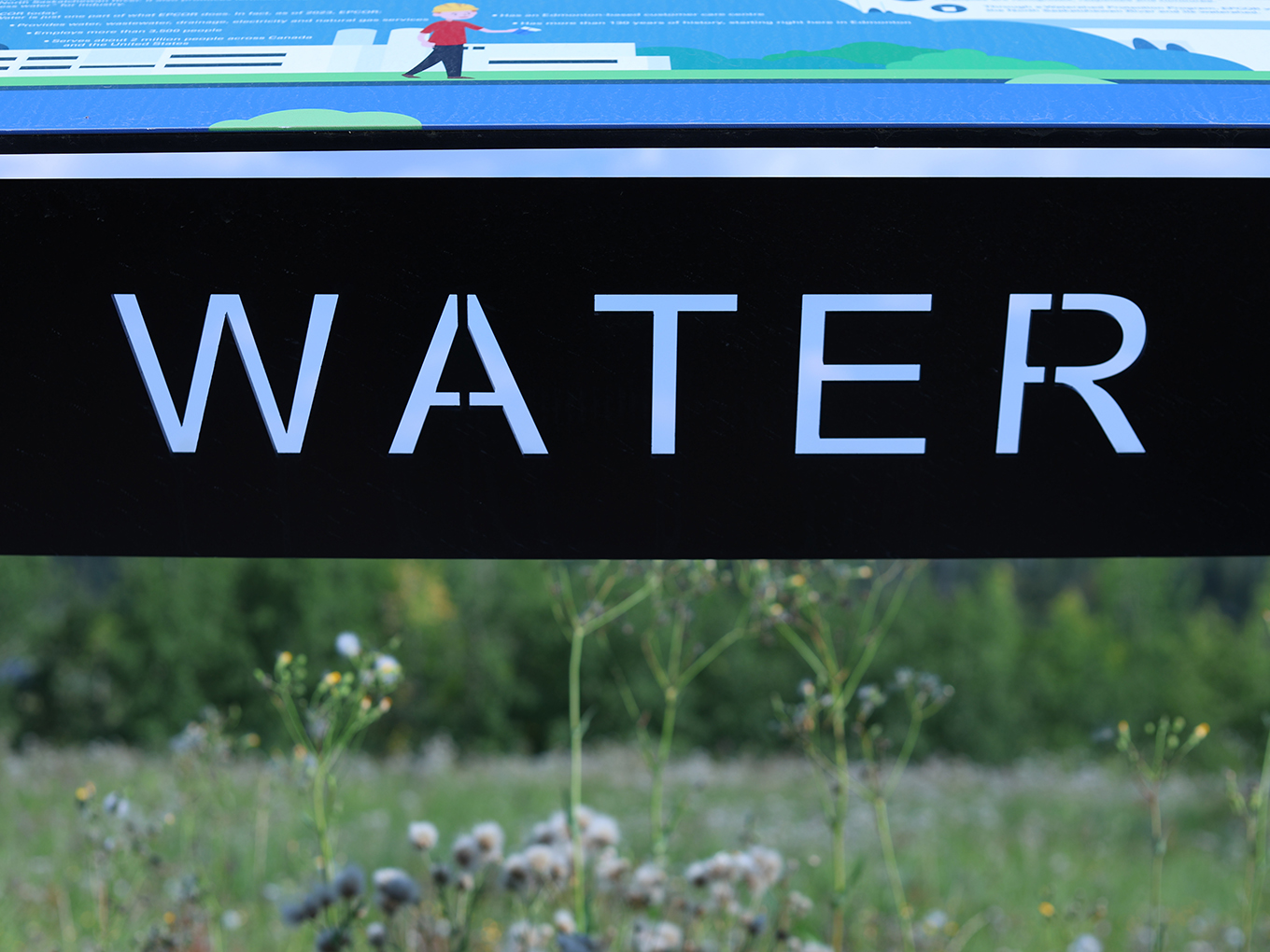 	Close-up of laser-cut "Water" lettering on a black powder-coated steel panel.