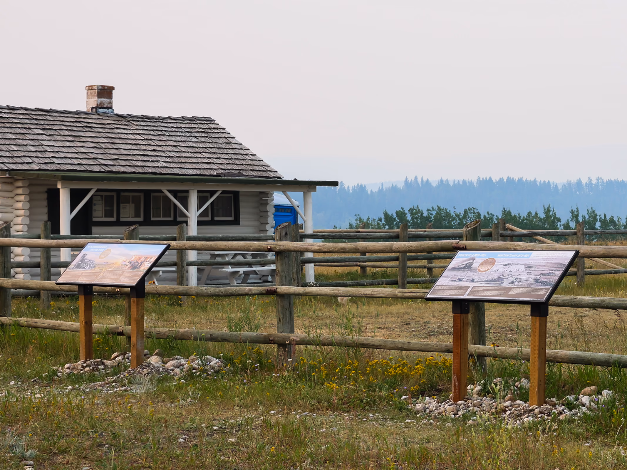 Two interpretive panels near the historic log cabin building on the Morleyville grounds.