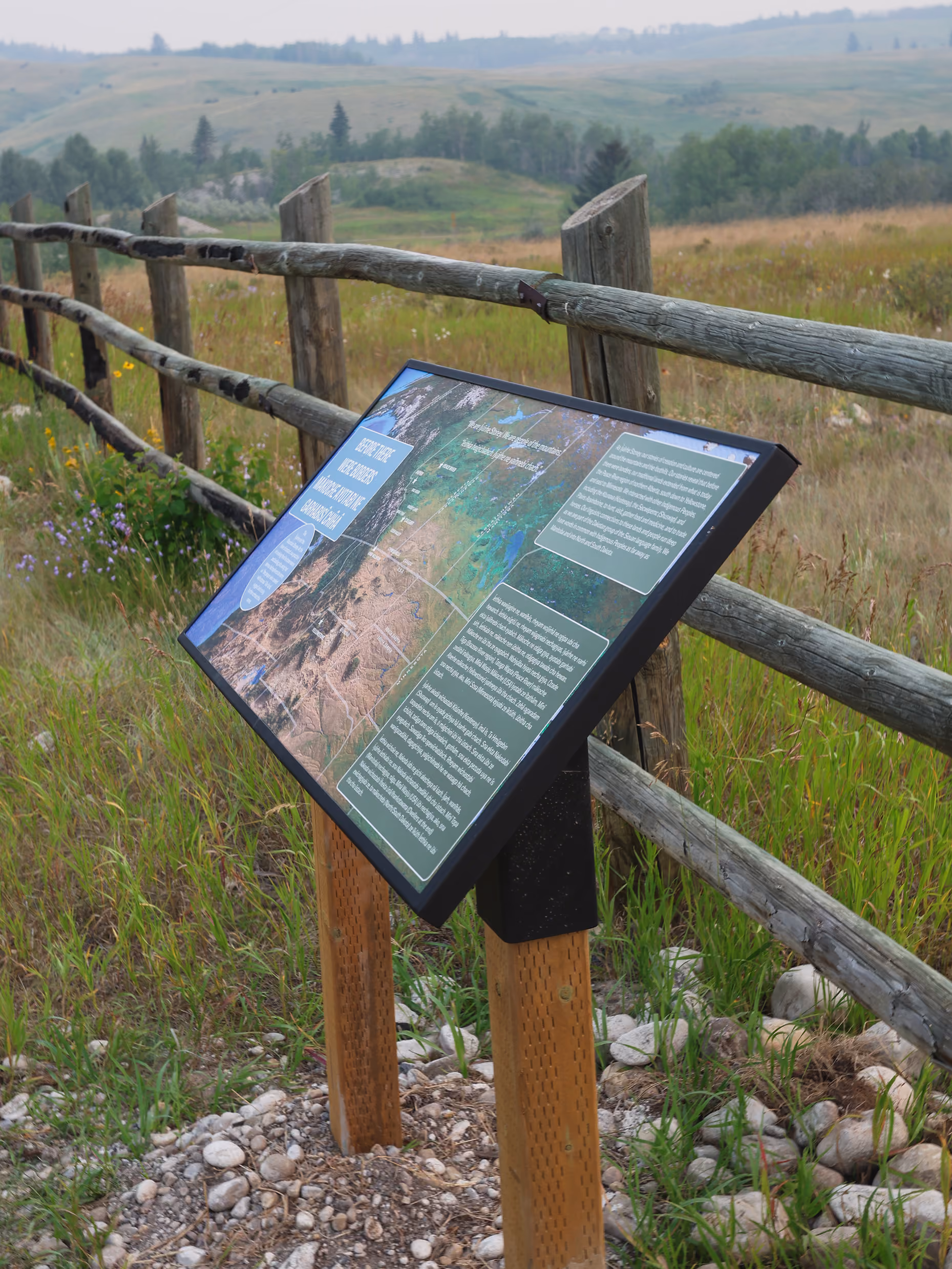 Close-up of the "Before There Were Borders" interpretive panel with rolling foothills in the background.