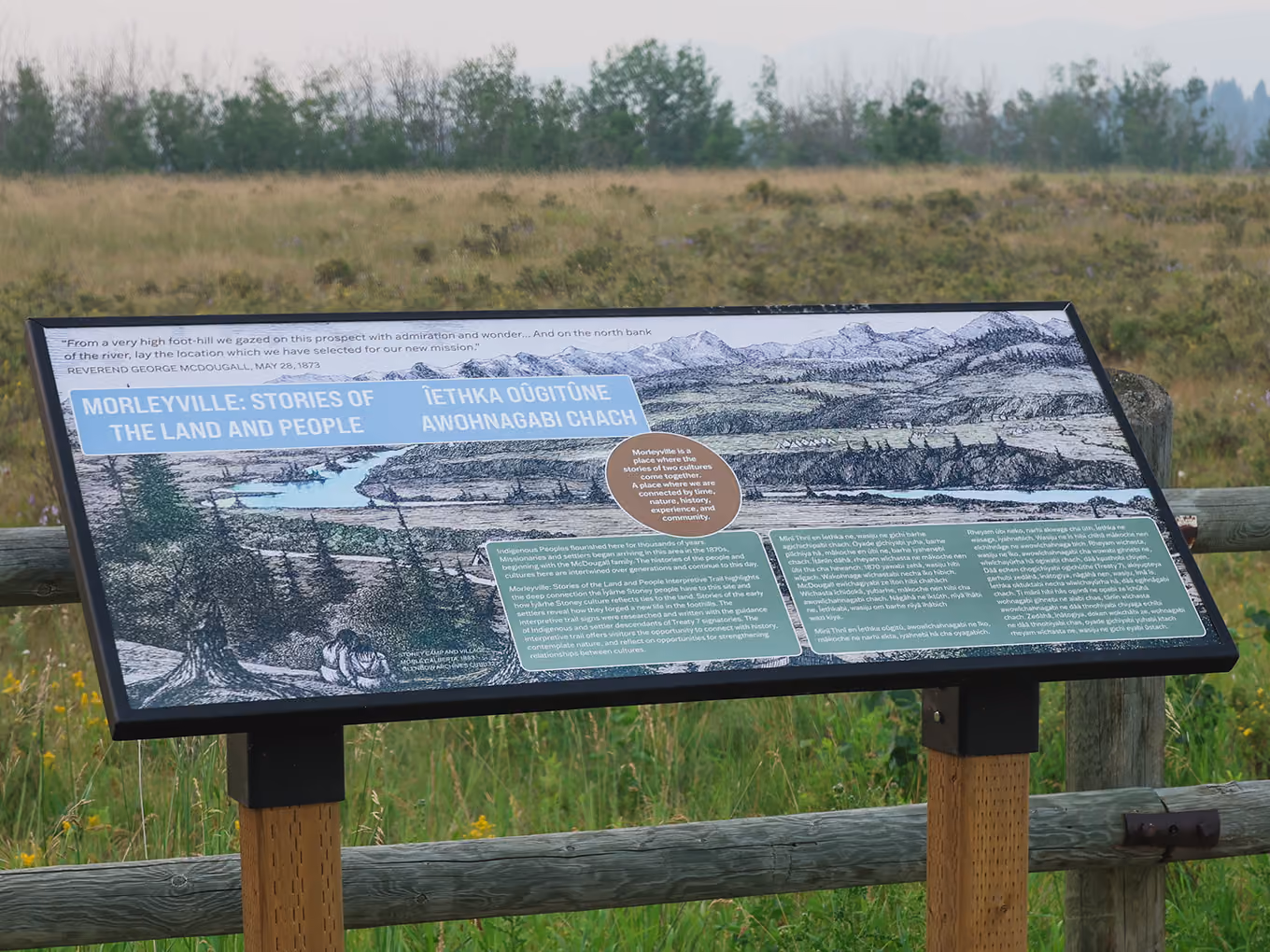 Close-up of the "Morleyville: Stories of the Land and People" bilingual interpretive panel on the open prairie.