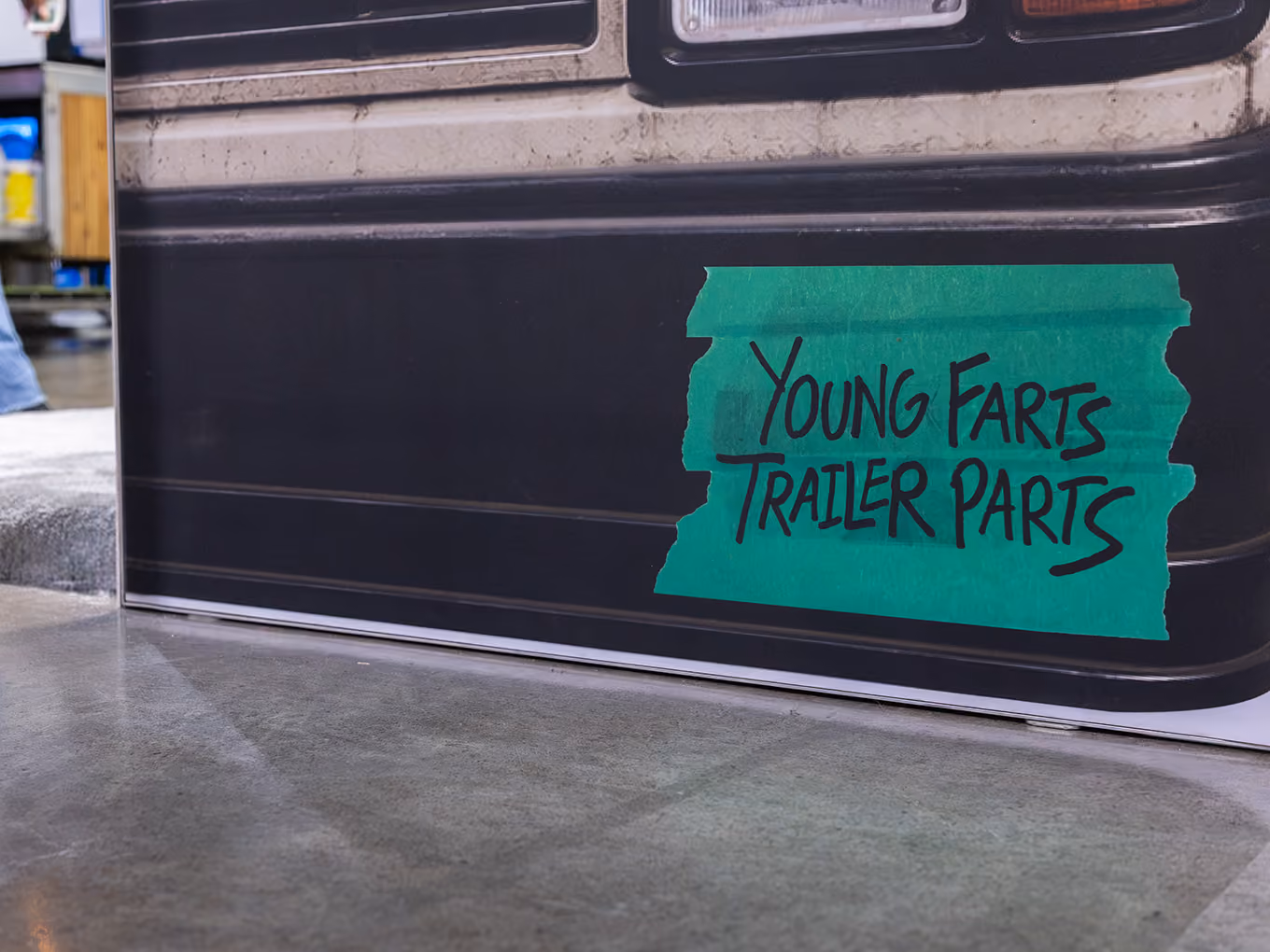 Close-up of the direct-print Young Farts Trailer Parts graphic sign on the custom RV façade.