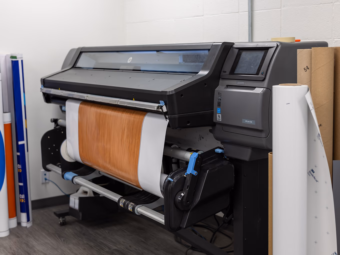 A large-format printer produces a wood-grain direct-print graphic used in the Young Farts Trailer Parts RV build.