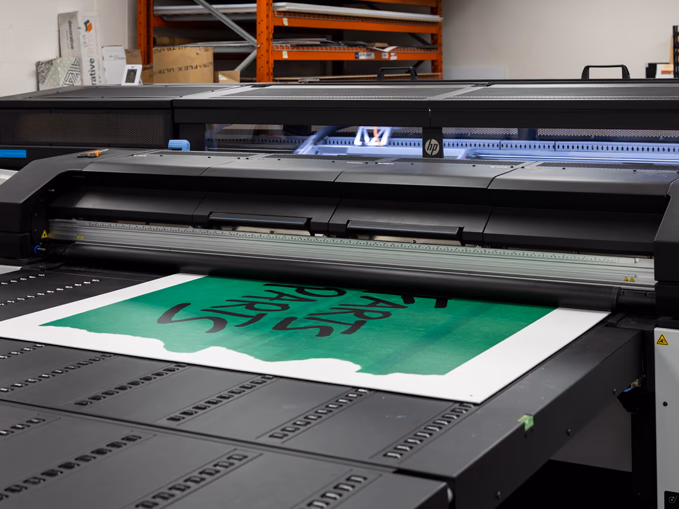 A large-format printer outputs the Young Farts Trailer Parts signage for the Calgary Stampede activation.