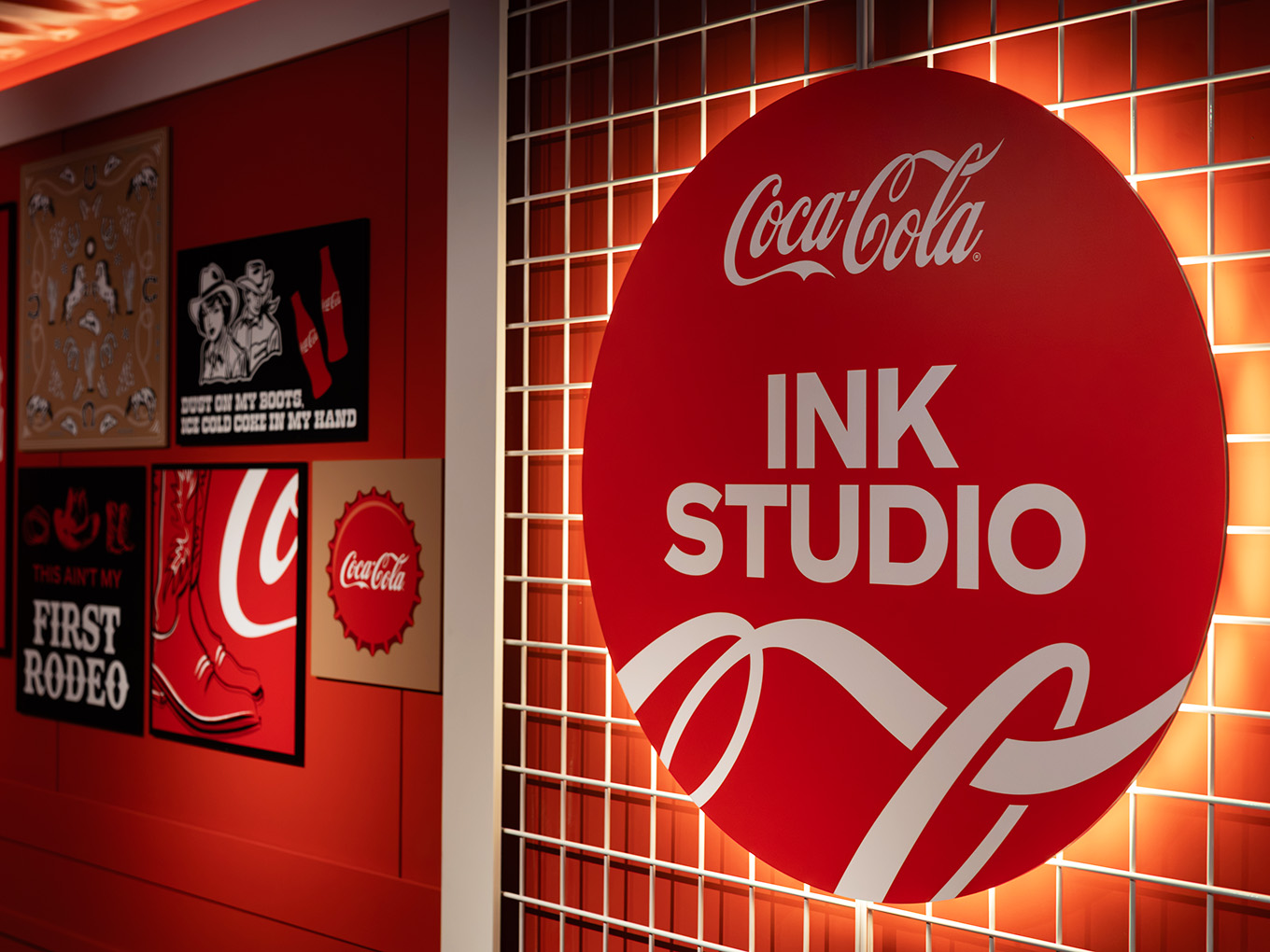 Backlit Ink Studio signage and cowboy-inspired Coca-Cola graphics on the custom gridwall solution.