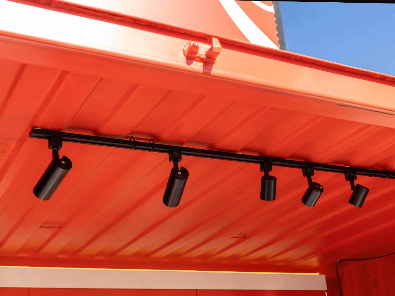 Detail of custom track lighting installed along the interior ceiling of the Coca-Cola Ink Studio seacan.