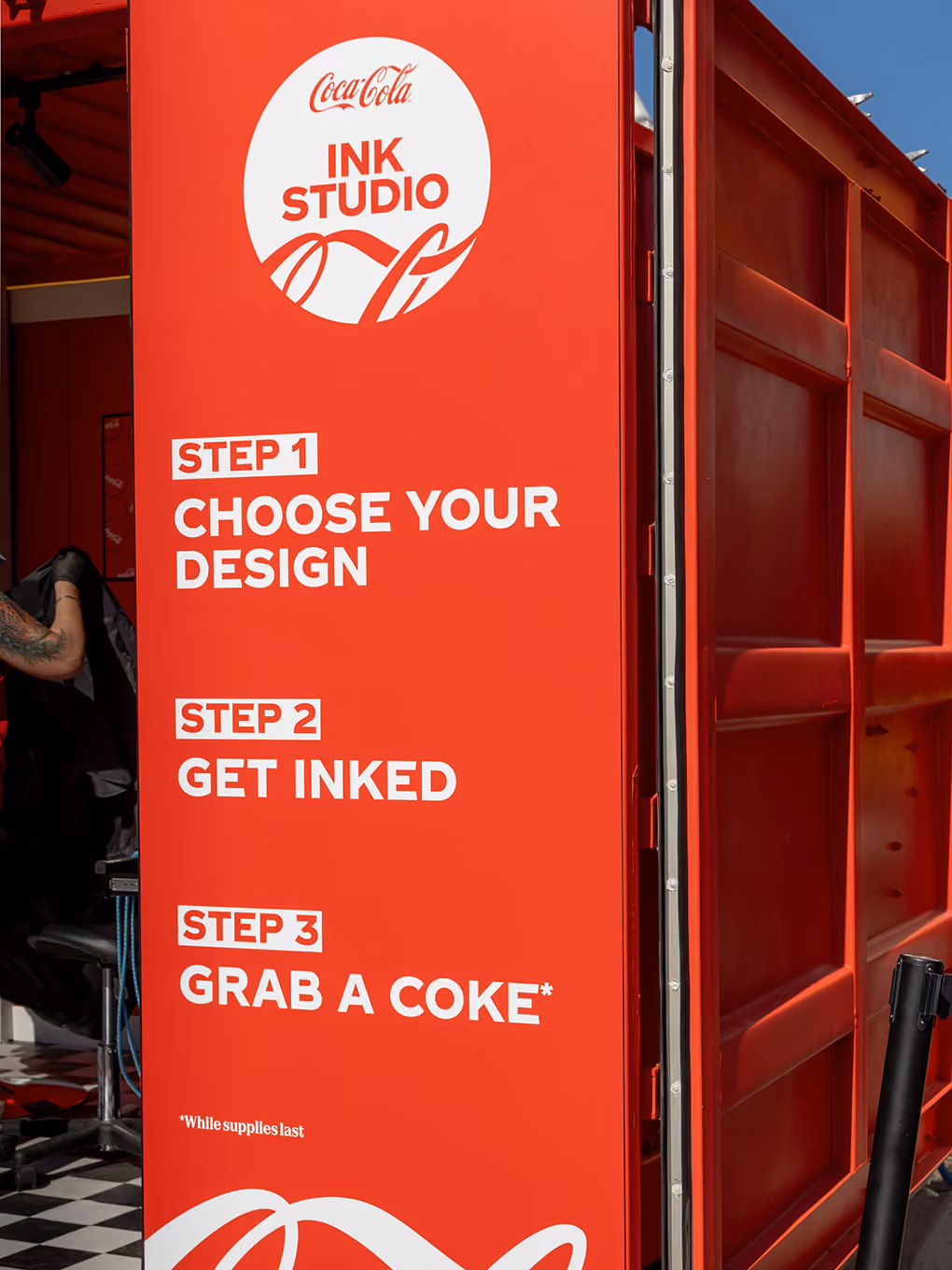 Custom printed signage panel outlining the three-step Coca-Cola Ink Studio visitor experience.