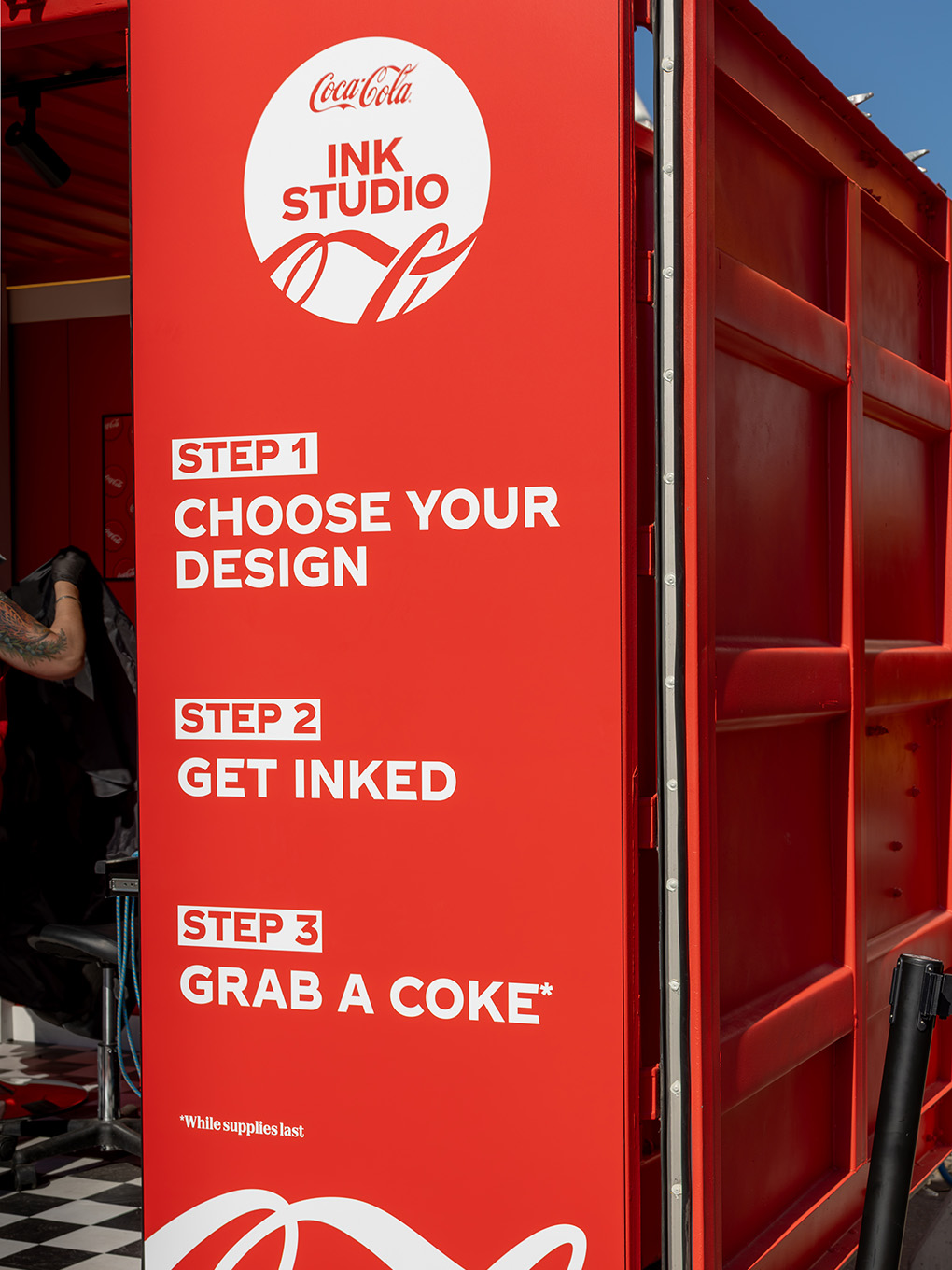 Custom printed signage panel outlining the three-step Coca-Cola Ink Studio visitor experience.