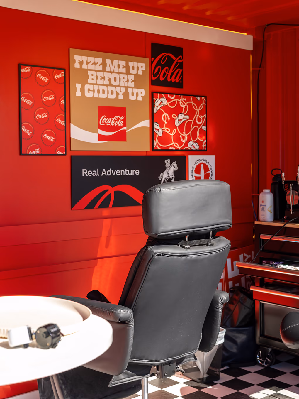 Tattoo chair and custom Coca-Cola cowboy graphics arranged along the seacan's fabricated feature wall.