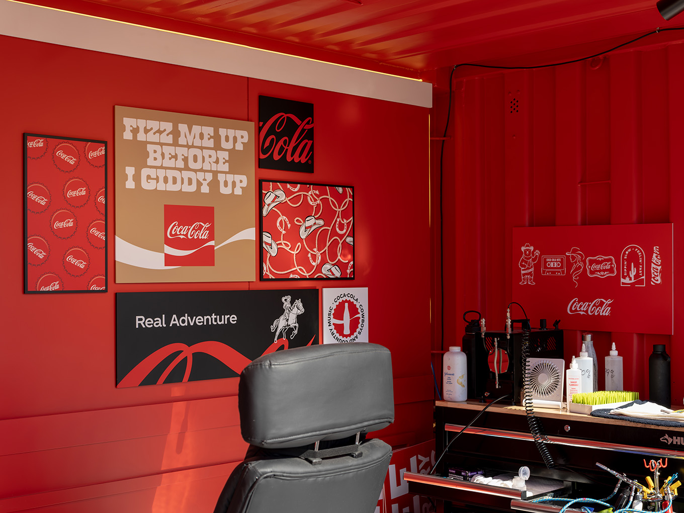 Custom rodeo-themed graphic panels and tattoo workstation inside the Coca-Cola Ink Studio seacan build.