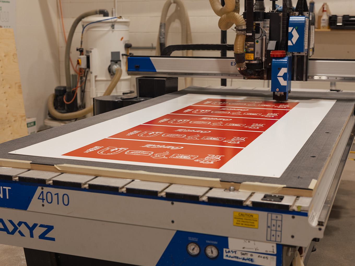 CNC router cutting custom Coca-Cola graphic panels during production of the Ink Studio seacan.