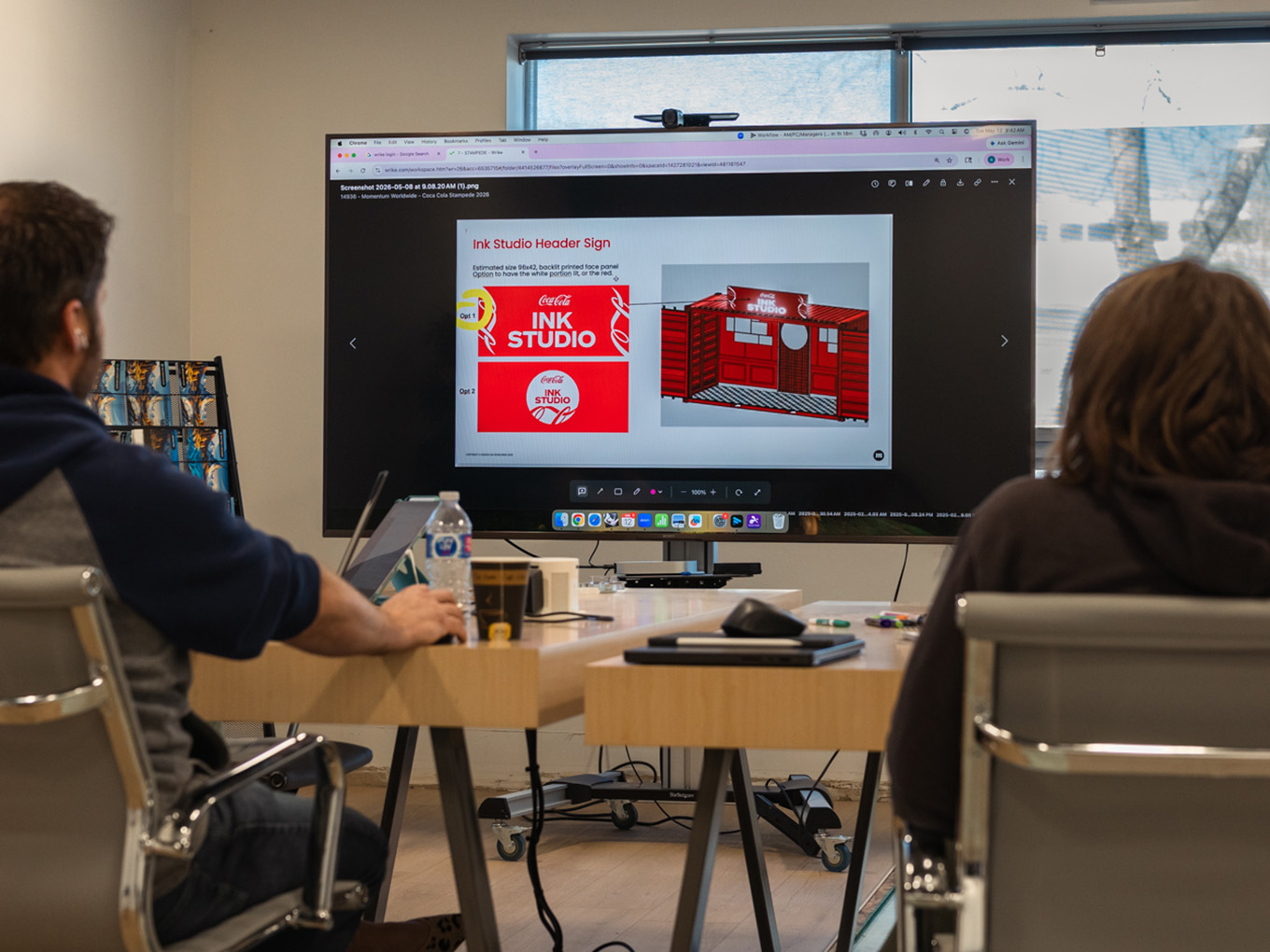 Exhibit Studio team reviewing Ink Studio header sign concepts on screen. 15. gallery-15_cokeSeacan_calgaryStampede.jpg Alt text: Exhibit Studio fabricator finishing 3D renderings of custom signage details on the Coca-Cola Ink Studio build.