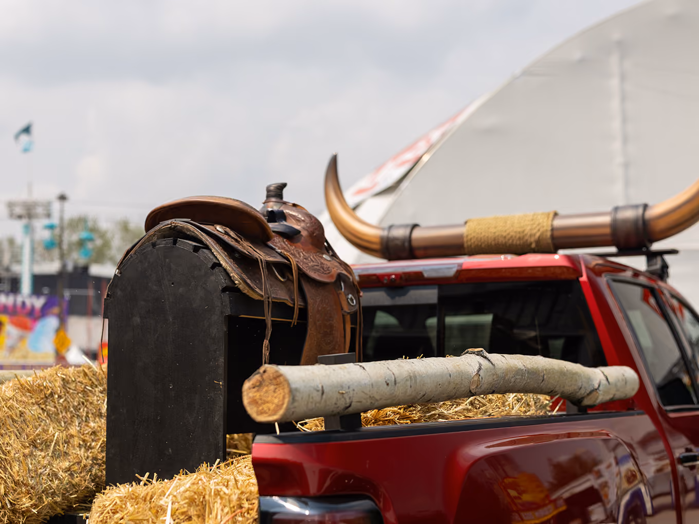 Detail of custom horn topper, saddle, and log rail styling on the GMC Stampede parade truck bed.